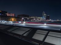 a bench that has lights on in the middle of it and in front of the city skyline