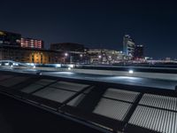 a bench that has lights on in the middle of it and in front of the city skyline