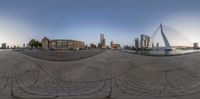 a fisheye view of city from across the riverbank of a harborfront area