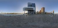 an image of a very beautiful building on the water coast way by some buildings in a big city