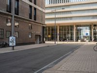 two people are standing on the sidewalk waiting for the light to come out of the building