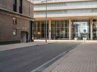 two people are standing on the sidewalk waiting for the light to come out of the building