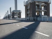 the city is empty of cars on the highway or in front of large pipes and chimneys