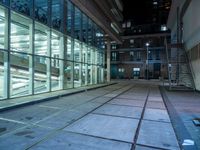 an empty parking lot with windows and stairs next to it is a street where the buildings are illuminated