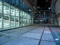 an empty parking lot with windows and stairs next to it is a street where the buildings are illuminated