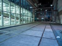 an empty parking lot with windows and stairs next to it is a street where the buildings are illuminated