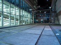 an empty parking lot with windows and stairs next to it is a street where the buildings are illuminated