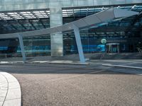 a man walks past an airport entrance with lots of windows and an arched sign for air traffic