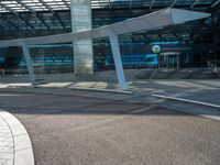 a man walks past an airport entrance with lots of windows and an arched sign for air traffic