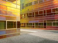 the facade of a building with multiple windows and a staircase to it that is next to a wall that is painted yellow, red and brown