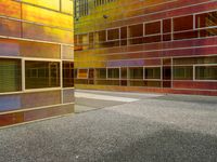 the facade of a building with multiple windows and a staircase to it that is next to a wall that is painted yellow, red and brown