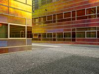 the facade of a building with multiple windows and a staircase to it that is next to a wall that is painted yellow, red and brown