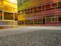 the facade of a building with multiple windows and a staircase to it that is next to a wall that is painted yellow, red and brown