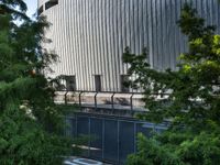 a view of an outdoor patio on a clear day with the building behind it and trees in front of it