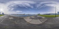 a fish eye view of a city in the distance with a skateboarder jumping