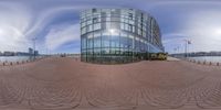 a very highrise building next to water and clouds at sunny day, with a circular pattern