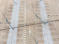 three light poles and two cars parked on the parking lot of an airport with markings on them