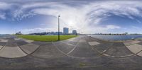 a view looking at the city skyline from the boardwalk area of this park as seen in a fish eye view