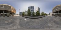 a fisheye lens view of some architecture and people walking near trees on a sidewalk