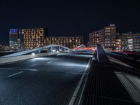 a train on an elevated track passing through a city at night, with buildings and cars