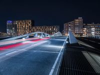 a train on an elevated track passing through a city at night, with buildings and cars