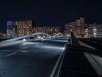 a train on an elevated track passing through a city at night, with buildings and cars