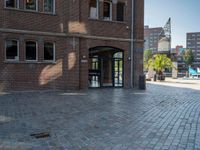 an entrance to a brick building with the clock tower in the background, taken from behind