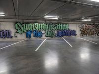 a parking garage with graffiti on the wall and two skateboards leaning up against each other