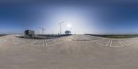 a 360 - turn picture of a parking lot with cars on it and an industrial building in the background