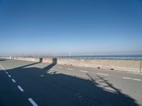 the shadow of a person on a skateboard on a highway with a sign in the distance