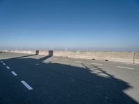 the shadow of a person on a skateboard on a highway with a sign in the distance