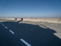 the shadow of a person on a skateboard on a highway with a sign in the distance