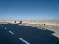 the shadow of a person on a skateboard on a highway with a sign in the distance