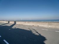 the shadow of a person on a skateboard on a highway with a sign in the distance