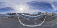 a skate board park with buildings and trees in the background while fisheye lens image is captured