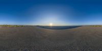 the sun is rising through the horizon and shining on the beach behind it in a circle