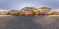 the buildings are in multicolored shapes at twilight as seen through a 360 - pan lens