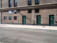 an image of a building that has green doors and windows in it's wall