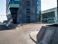 a skateboarder in action on the edge of a concrete ramp near buildings and a street