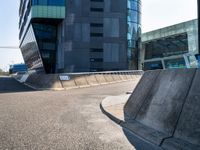 a skateboarder in action on the edge of a concrete ramp near buildings and a street