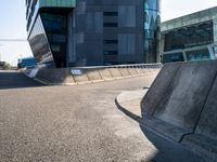 a skateboarder in action on the edge of a concrete ramp near buildings and a street