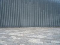 grey metal wall with many tiles near by and on top of it's brick surface