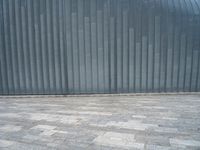 grey metal wall with many tiles near by and on top of it's brick surface