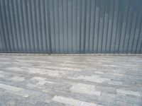 grey metal wall with many tiles near by and on top of it's brick surface