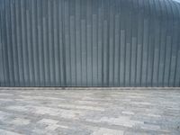 grey metal wall with many tiles near by and on top of it's brick surface