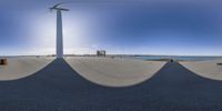 the view from a fisheye looking into an island with two windmill's by water