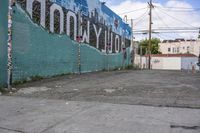 a street corner with a mural in the back, a sign that says hollywood on the side, and a stop sign on the sidewalk