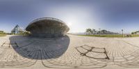 a fish - eye view of a circular brick structure with a person on a bike in the foreground