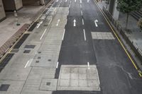 an aerial view of a roadway that has arrows on both sides and yellow lines down the middle