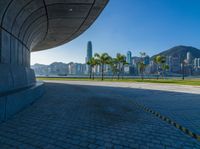 a large tunnel on the road with palm trees in the background and buildings in the distance